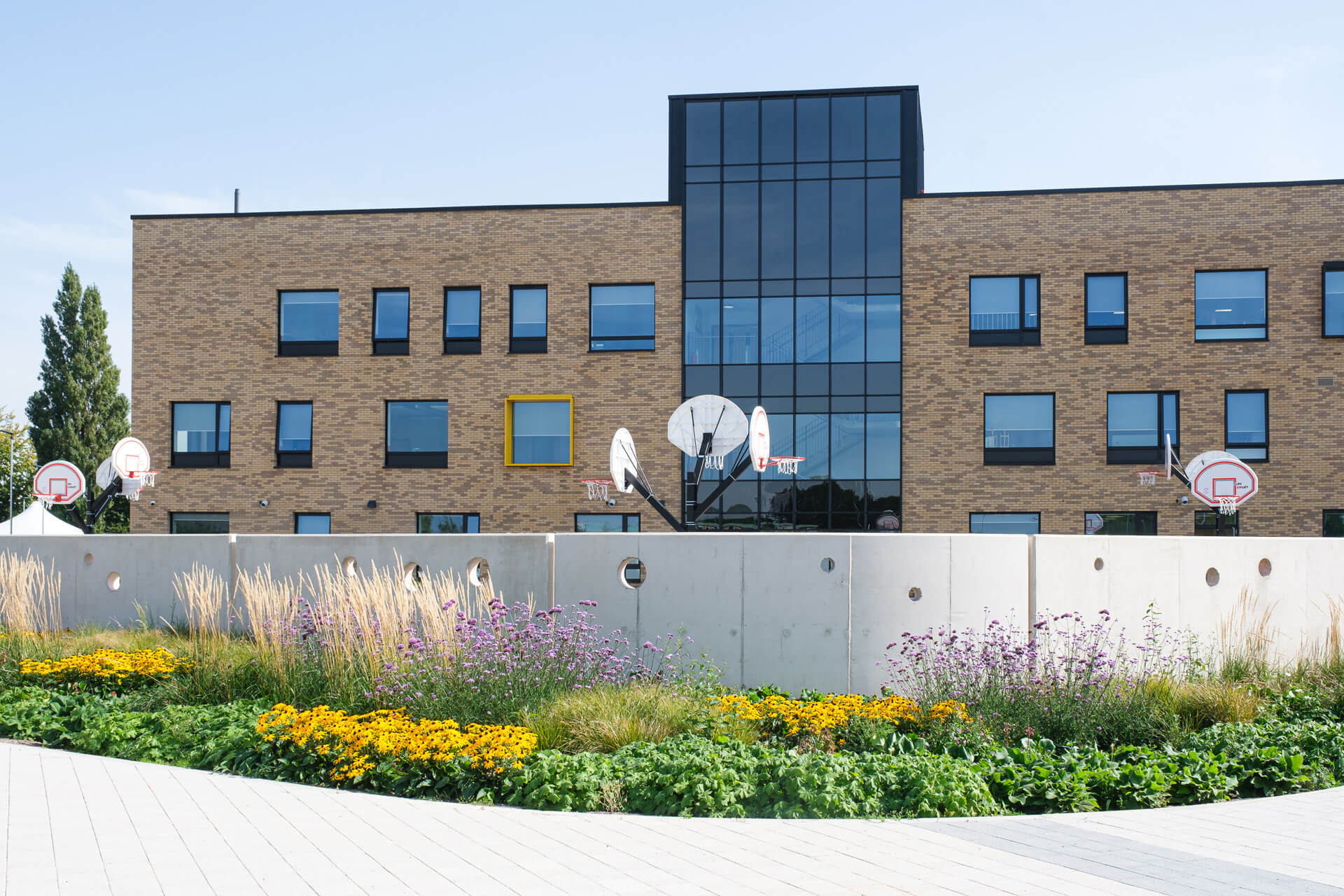 Image of the exterior of Fitzalan High School with a flower garden